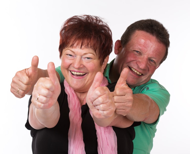 erfolgreiches Seniorenpaar mit Daumen hoch Durch Immobilienrente zu Lebzeiten das Haus als Erbe verteilen
